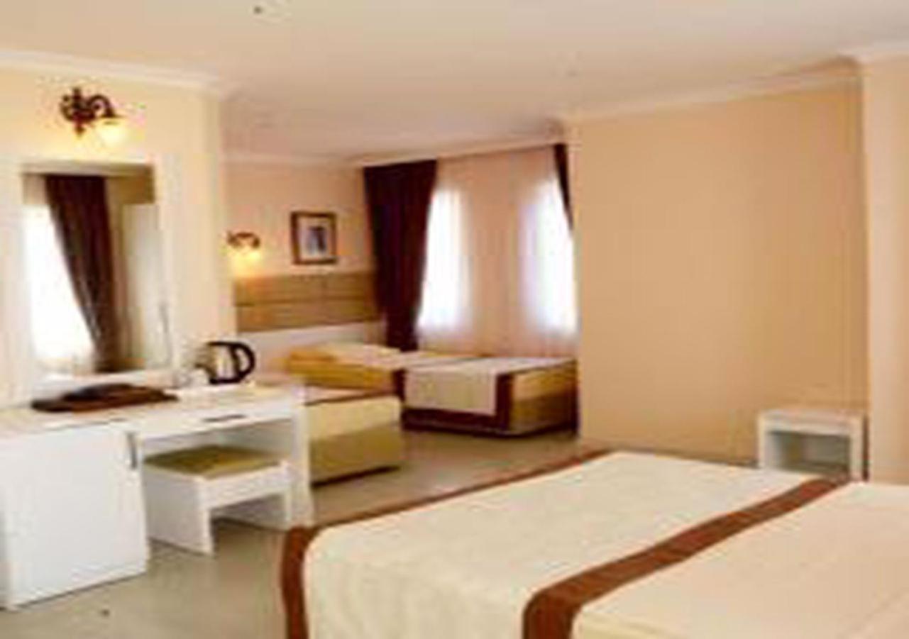 Miramor Hotel & Spa Antália Exterior foto The photo shows a hotel room with two beds and a cozy, inviting atmosphere. One bed is larger, possibly a queen or king size, and is draped with a light-colored bedspread that has a brown accent. The room has light-colored walls and natural light str
